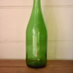 Può includere: Una bottiglia di vetro verde con un'etichetta che dice "La Sima".