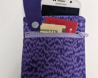 May include: Purple zippered pouch with a phone, credit card, and cash inside. The pouch has a purple strap with a silver button.