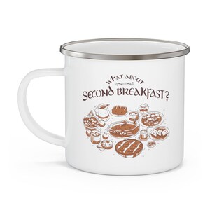 May include: White enamel mug with a silver rim featuring a brown illustration of a spread of food with the text "What about Second Breakfast?"