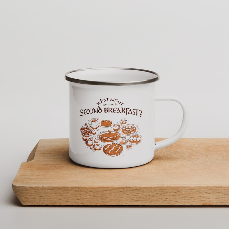 May include: White enamel mug with a brown illustration of various breakfast foods and the text "What about Second Breakfast?" printed on it.