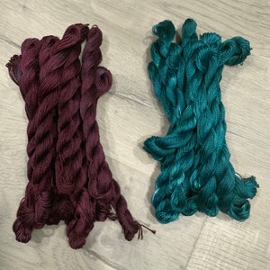 May include: Two bundles of embroidery floss, one burgundy and one teal.