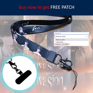 以下が含まれることがあります： アニメキャラクターの画像と「LOVE AND DEEP SPACE」のテキストが入った黒いランヤード。黒い留め金と携帯電話ホルダーが付いています。「buy now to get FREE PATCH」のテキストも含まれています。