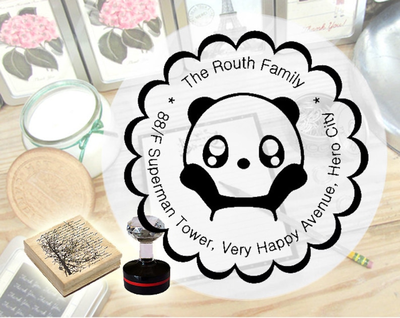 K&ouml;nnte beinhalten: Eine Schwarzwei&szlig;-Illustration eines Pandas mit gro&szlig;en Augen und einer kleinen Nase. Die Illustration ist von einem Kreis mit dem Text "The Routh Family * 88/F Superman Tower, Very Happy Avenue, Hero City *" in Schwarz umgeben.