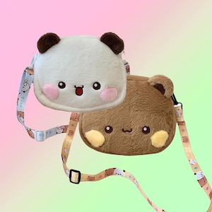 May include: Two plush crossbody bags shaped like cartoon animals. One is white with brown ears and a panda-like design, the other is brown with a bear-like design. Both have embroidered facial features and pink cheeks. The bags have adjustable straps.