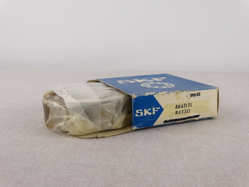 May include: A blue and white box with the text "SKF" on it. The box contains a bearing with the numbers "AK43131 K4331Z" on it.