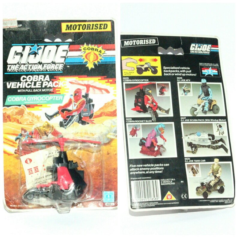 May include: A vintage G.I. Joe Cobra Gyrocoptor toy vehicle pack. The red and black toy helicopter has a pull-back motor and comes with a Cobra soldier figure. The packaging features the G.I. Joe logo and the words "Cobra Vehicle Pack" and "Cobra Gyrocoptor".