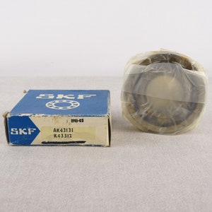 May include: A blue and white box with the text "SKF" and "AK43131 K43312" on it. The box contains a round, silver bearing with a clear plastic cover.