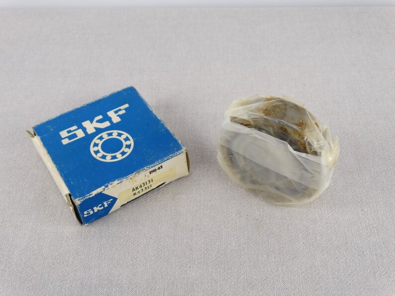 May include: A blue box with the SKF logo and the text "AK41131 K 43131" on it. The box contains a new SKF bearing, wrapped in clear plastic.