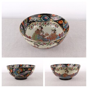 Könnte beinhalten: Eine schwarze und weiße Keramikschüssel mit einem bunten Blumendesign und einer Szene mit drei Frauen in traditioneller japanischer Kleidung. Die Schüssel hat einen goldenen Rand.