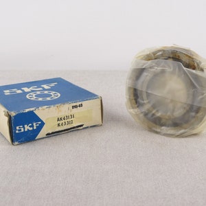 May include: A blue and white box with the SKF logo and the text "AK43131 K43312" on it. A silver ball bearing is wrapped in plastic.