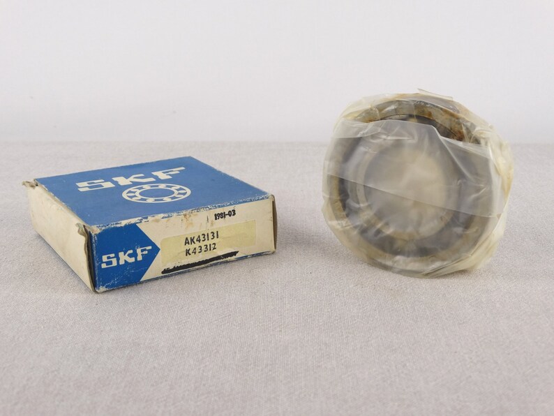 May include: A blue and white box with the SKF logo and the text "AK43131 K43312" on it. A silver ball bearing is wrapped in plastic.