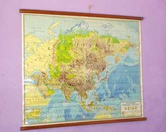 May include: A vintage, framed map of Asia with a wooden frame. The map is in Greek and shows the physical features of the continent. The map is titled "GEOGRAPHIKOS DIAITIKOS ASIAZ".