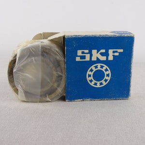 May include: A new, sealed, SKF ball bearing in a blue and white box. The box features the SKF logo and a drawing of a ball bearing.