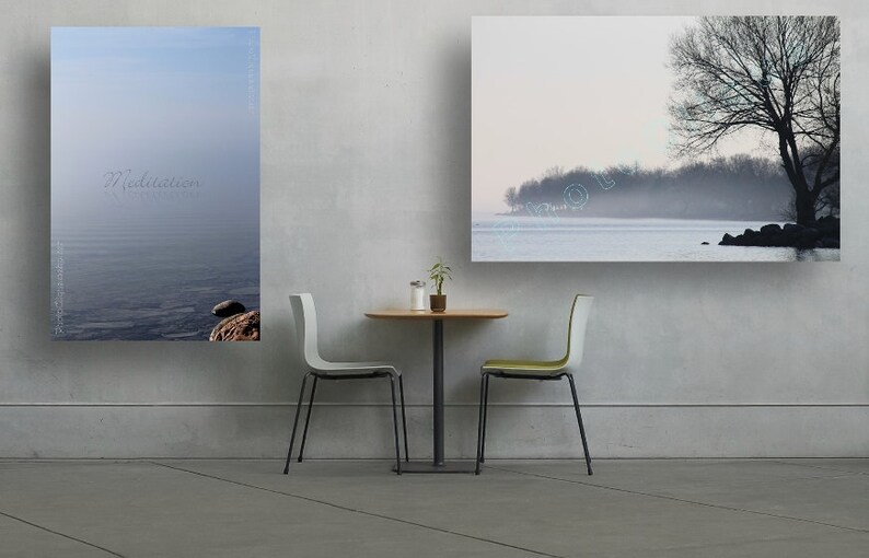 May include: Two framed landscape photographs of a lake with a tree in the foreground and a misty background. The photographs are hanging on a white wall above a small table with two chairs.