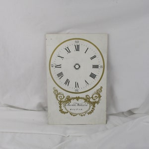May include: White clock face with black Roman numeral markings and gold accents. The clock face is labeled "Aaron Willard, Boston".