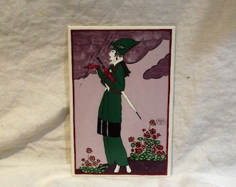 May include: A vintage tile featuring a woman in a green coat and hat holding an umbrella, standing in a field of red flowers against a purple cloudy sky.