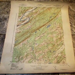 May include: A vintage topographic map of the Flatbrookville Quadrangle, featuring detailed contour lines, waterways, and geographical features. The map is printed on aged paper with a grid overlay and text labels. The map is in shades of green, brown, and blue.