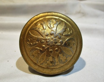 May include: A gold-toned metal door knob with a decorative floral design.