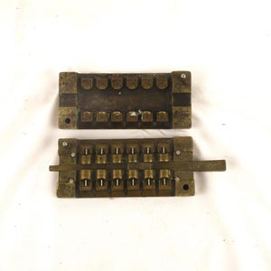 May include: Two antique brass pieces with a series of small holes and a lever. The lever is labeled "1/10" and "90".