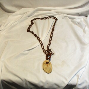May include: A rusty metal chain with a white oval tag attached. The tag has the number "31" printed on it.