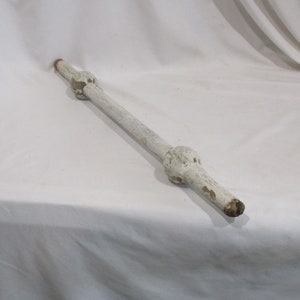May include: White painted wooden rod with two round knobs. The rod is approximately 18 inches long.
