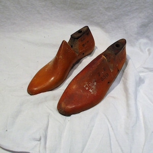 May include: Two wooden shoe lasts, one with the size 7 E 550 printed on it and the other with the size 9 1/2 11 1/2 printed on it.