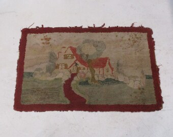 May include: A vintage rug with a hand-stitched design of a house with a red roof and a tree in front of it. The rug has a red border and is made of wool.