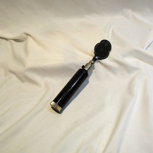 May include: A black metal ear trumpet with a round, black earpiece. The ear trumpet is about 10 inches long.
