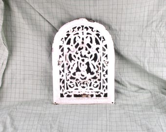 May include: White cast iron decorative vent cover with a detailed floral design. The vent cover is arched at the top and has a white painted finish.