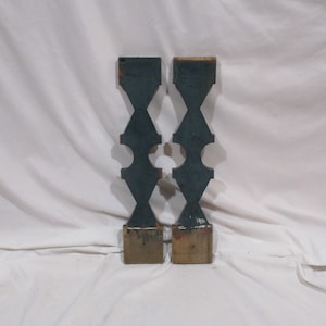 May include: Two wooden finials painted dark blue with a geometric design. The finials are attached to a wooden base.