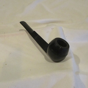 May include: A black wooden pipe with a round bowl and a long, thin stem.