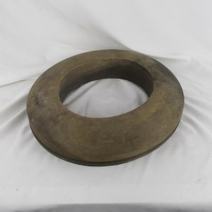 May include: A wooden hat form, shaped like a ring, with a dark brown color and a smooth surface.