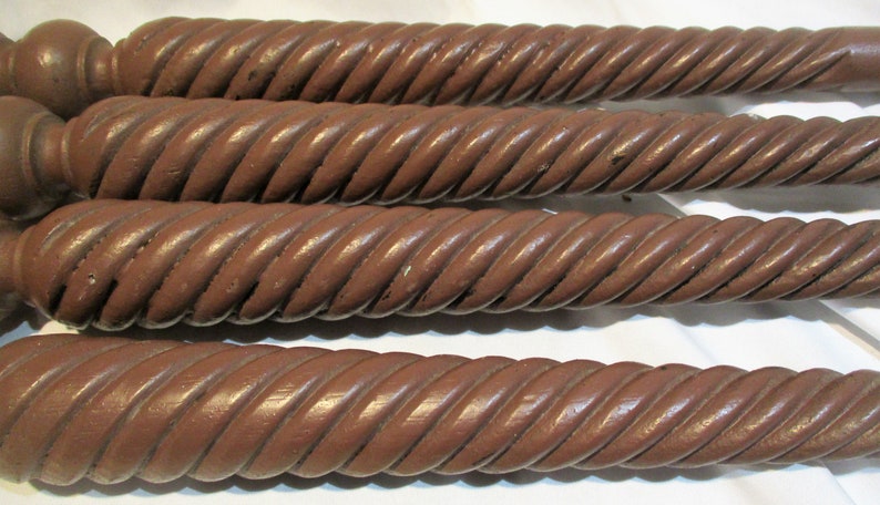 May include: Four brown wooden table legs with a rope-like design. The legs are all the same size and shape.