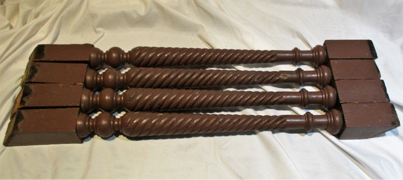 May include: Five dark brown wooden table legs with a twisted design and a rounded top.
