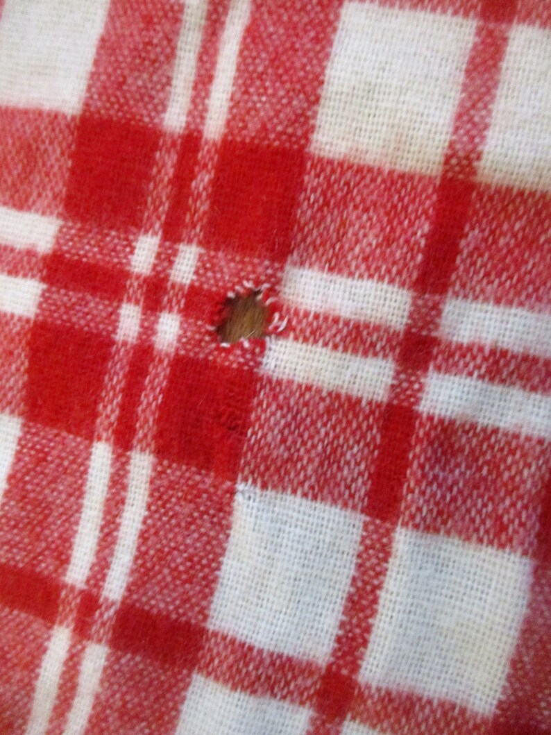 May include: Red and white checkered fabric with a small hole in the center.