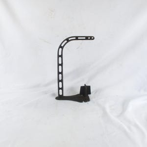 May include: A dark, weathered cast iron boot jack featuring an L-shaped frame with a series of elongated, vertical cutouts along the vertical post and horizontal arm, ending in a solid, flared base with a small, raised, four-pointed metal wedge.
