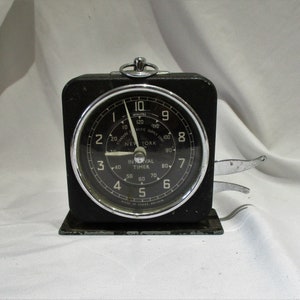 May include: A black interval timer with a silver face and a silver knob. The face has white markings and the text "Interval Timer" and "New York".