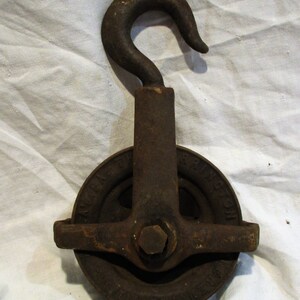May include: A vintage cast iron pulley with a hook, featuring the text "Austin Mfg. Co.  Spring City, Pa."