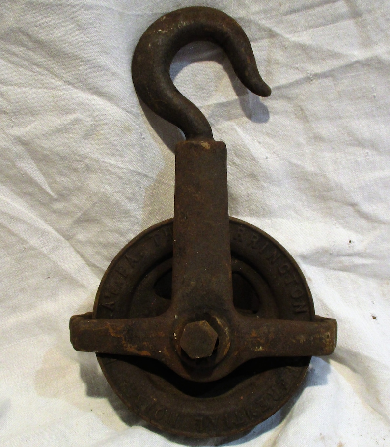 May include: A vintage cast iron pulley with a hook, featuring the text "Austin Mfg. Co.  Spring City, Pa."