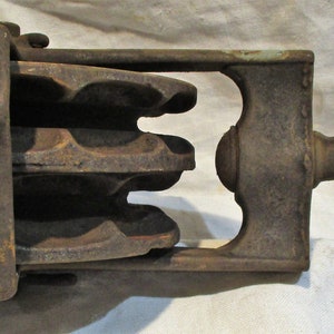 Pu&ograve; includere: Una carrucola vintage in ghisa con un gancio. La carrucola ha quattro scanalature ed &egrave; realizzata in metallo grigio scuro. Il gancio &egrave; anch'esso realizzato in metallo grigio scuro ed &egrave; piegato ad un angolo di 90 gradi.