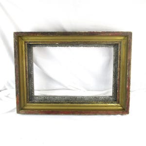 May include: Rectangular picture frame with a distressed finish. The frame has a gold inner border, a gray middle section, and a red-brown outer edge. The frame is empty, with no picture inside.