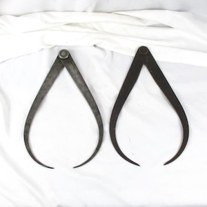 May include: A white ceramic mug with a black handle and the text "But First, Coffee" in a handwritten style. The mug is on a white surface. The mug is approximately 4 inches tall.