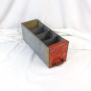 May include: A white ceramic mug with a black handle and the text "But First, Coffee" in a bold, black font. The mug is set against a blurred background, suggesting a cozy setting. The mug appears to be approximately 4 inches tall.