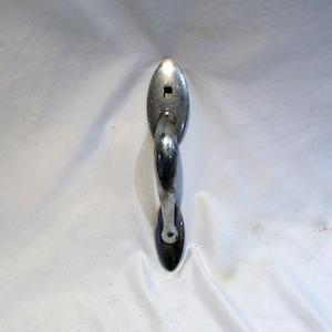 May include: A silver door handle with a rounded oval shape and a keyhole. The handle has a curved design and a smooth finish.
