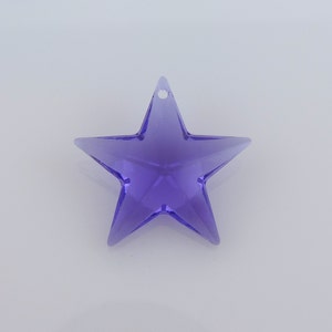 May include: A translucent, purple star-shaped ornament with a small hole for hanging. The star has five points and is made of a clear, shiny material. The ornament is set against a plain white background.
