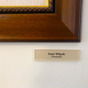 May include: A beige rectangular sign with black text that reads "Ivan Vityuk Firewood".