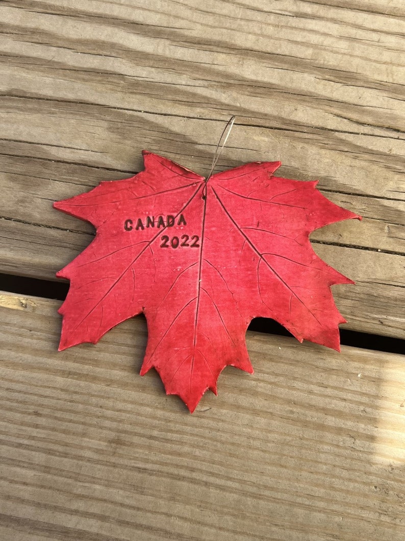 K&ouml;nnte beinhalten: Ein rotes Ahornblatt mit dem Aufdruck "CANADA 2022".