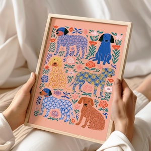 以下が含まれることがあります： ピーチ色の背景に6匹の犬が描かれた長方形の額入りアートプリント。青い花柄、黄色いペイズリー柄、無地の茶色など、様々なポーズや模様の犬が、赤、ピンク、緑の植物のイラストと共に配置されています。