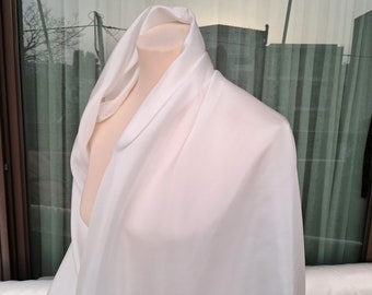 Op de afbeelding: Een witte stof gedrapeerd over een mannequin, die de gladde textuur en de zachte drapeert laat zien.