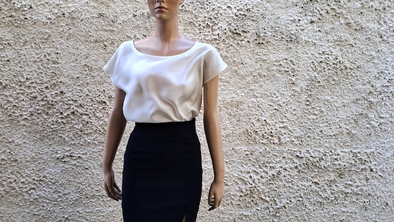 K&ouml;nnte beinhalten: Eine wei&szlig;e Bluse mit kurzen &Auml;rmeln, Rundhalsausschnitt und schwarzem Bleistiftrock.
